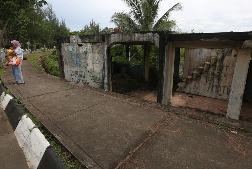 Warga berdiri di dekat rumah yang rusak parah sisa bencana gelombang gempa dan tsunami 26 Desember 2004 di Ulee Lheu, Banda Aceh, Kamis (4/12).