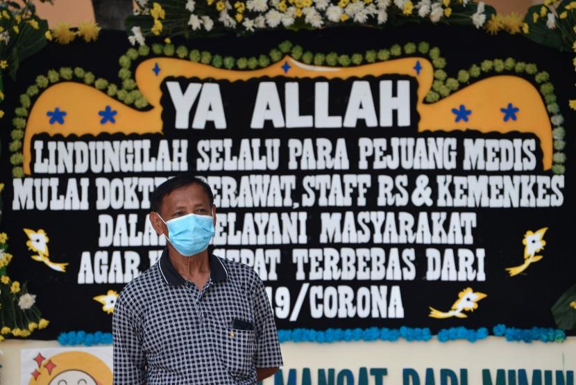 Warga berdiri di depan karangan bunga dukungan untuk tenaga medis dan staf Rumah Sakit Penyakit Infeksi (RSPI) Sulianti Saroso di Jakarta, Sabtu (21/3). (Antara/Aditya Pradana Putra)