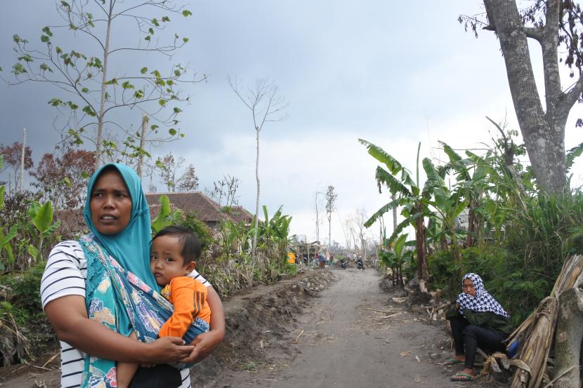 Warga berdiri kawasan permukiman yang terdampak awan panas guguran (APG) erupsi Gunung Semeru di Desa Supiturang, Pronojiwo, Lumajang, Jawa Timur. Viral video seorang pria diduga menendang sesajen di kawasan Gunung Semeru.