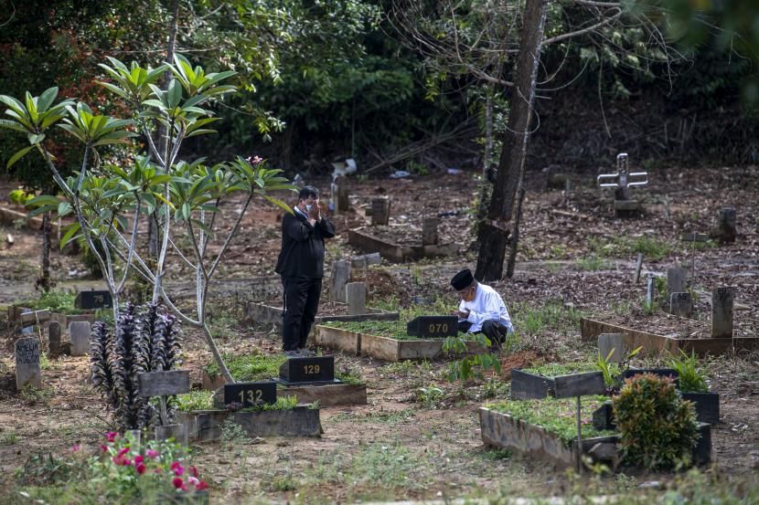 Warga berdoa di depan pusara keluarganya saat ziarah kubur di pemakaman 