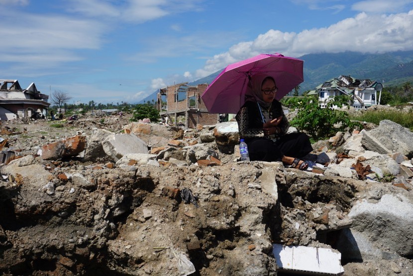 Warga berdoa di tempat hilangnya anggota keluarga mereka di lokasi bekas terdampak likuefaksi di Kelurahan Balaroa, Palu, Sulawesi Tengah, Rabu (5/6/2019).