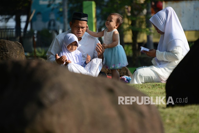 Warga berdoa untuk keluarganya saat ziarah di kuburan masal tsunami Ulee Lheue, Banda Aceh, Aceh, Kamis (26/12/2019). 