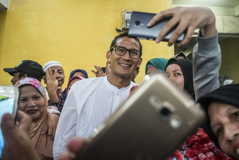 Warga berebut foto dengan calon Wakil Gubernur DKI Jakarta Sandiaga S. Uno (tengah) seusai berdialog di pendukungnya di Kemayoran, Jakarta, Jumat (11/11). 
