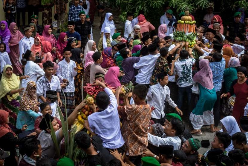 Warga berebut gunungan hasil bumi dalam prosesi Tradisi Grebeg Suro Girikusumo di Desa Banyumeneng, Mranggen, Demak, Jawa Tengah, Kamis (21/9). 