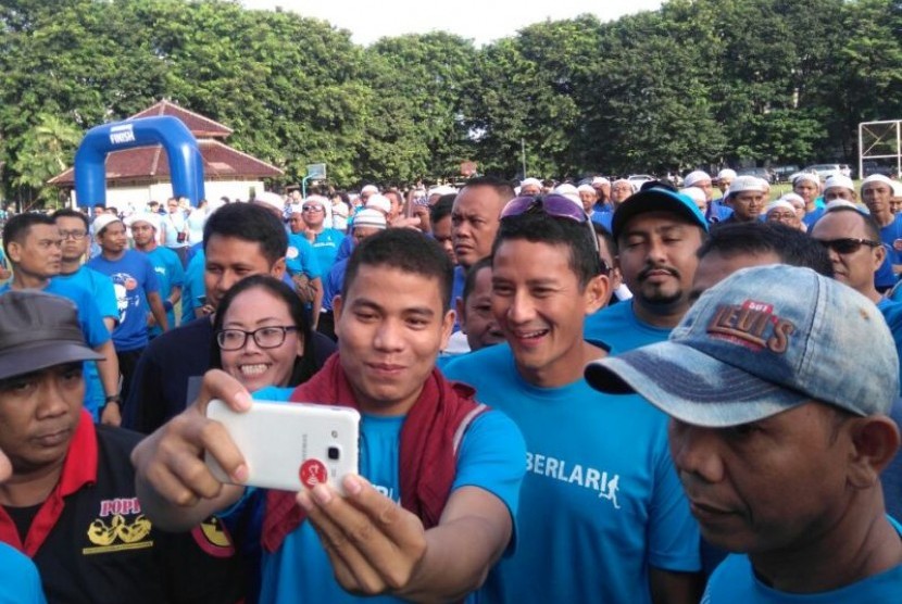 Warga berebut selfie dengan Cawagub DKI Jakarta Sandiaga Uno dalam acara Jakarta BERLARI di Lapangan Banteng, Jakarta, Ahad (2/10)