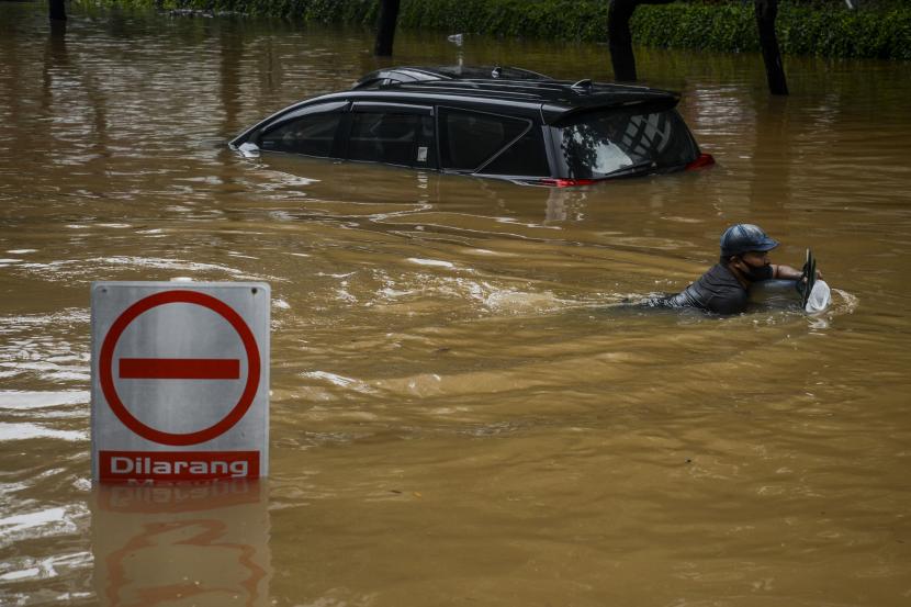 Warga berenang melewati banjir di kawasan Kemang, Jakarta, Sabtu (20/2).