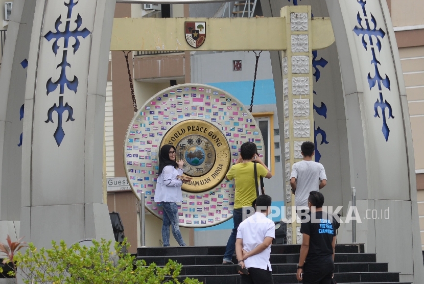  Warga berfoto di depan Gong Perdamaian Dunia (World Peace Gong di Kota Ambon, Maluku.