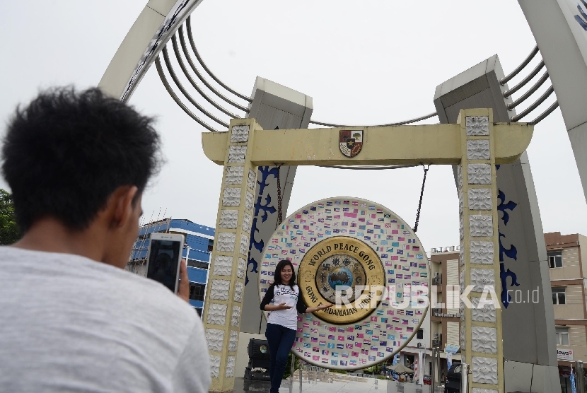 Warga berfoto di depan Gong Perdamaian Dunia (World Peace Gong0 di Kota Ambon, Maluku,