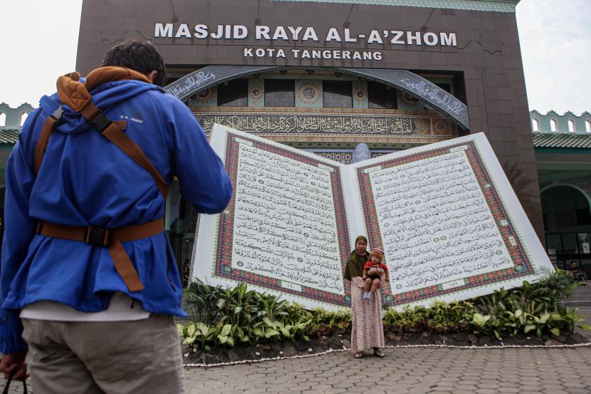 Warga berfoto di replika Al Quran raksasa pada Festival Al-Azhom 2022 di Kota Tangerang, Banten, Jumat (23/9/2022). Pemkot Tangerang Mulai Bangun Gedung MUI di Kecamatan Karang Tengah