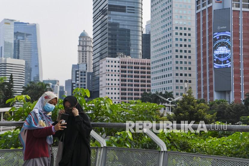 Warga berfoto di Spot Budaya Dukuh Atas dengan latar belakang gedung perkantoran di Jakarta, Rabu (17/3). Pemerintah menyuarakan pertumbuhan ekonomi Indonesia akan tumbuh tujuh persen pada kuartal II 2021.