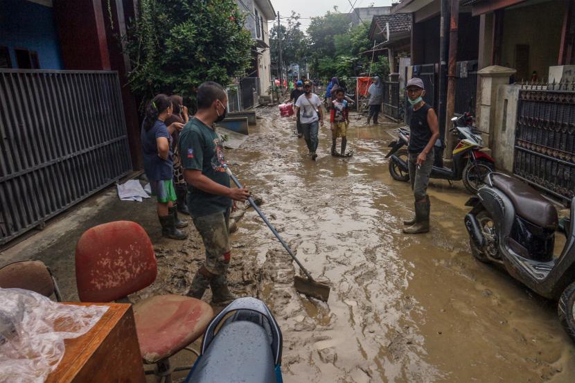 Warga bergotong royong membersihkan sisa lumpur banjir di Perumahan Villa Nusa Indah 2, Bojong Kulur, Kabupaten Bogor, Jawa Barat, Jumat (18/2/2022). Banjir terjadi di kawasan tersebut pada Rabu (16/2) malam disebabkan tingginya curah hujan sehingga menyebabkan meluapnya Sungai Cileungsi. Masyarakat meminta percepatan normalisasi Sungai Cileungsi-Cikeas karena kerap banjir