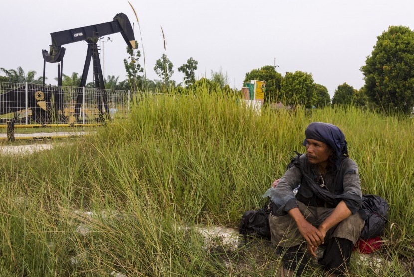 Warga beristirahat di dekat monumen pompa angguk minyak di Blok Rokan di Riau (ilustrasi). PLN dan Pertamina masih membahas rencana kerja sama pasokan listrik dan uap ke WK Rokan.