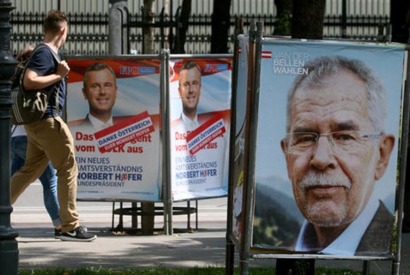 Warga berjalan di antara poster kampanye kandidat presiden Austria dan mantan ketua Partai Hijau Alexander Van der Bellen (kanan), dan kandidat presiden dari Partai Kebebasan Norbert Hofer (kiri), Senin, 23 Mei 2016.