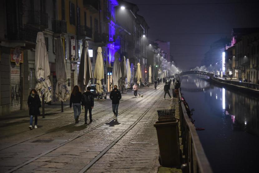   Warga berjalan di area Navigli, saat gelombang kedua pandemi Covid-19, di Milan, Italia, (14/11). Lombardy berada di zona merah dengan tingkat pembatasan tertinggi.