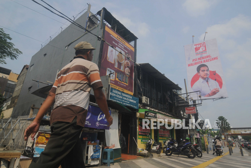 Warga berjalan di dekat baliho bergambar Kaesang Pangarep di Jalan Margonda Raya, Kota Depok. Relawan mendukung Kaesang untuk membasmi delapan tuyul meresahkan di Kota Depok.