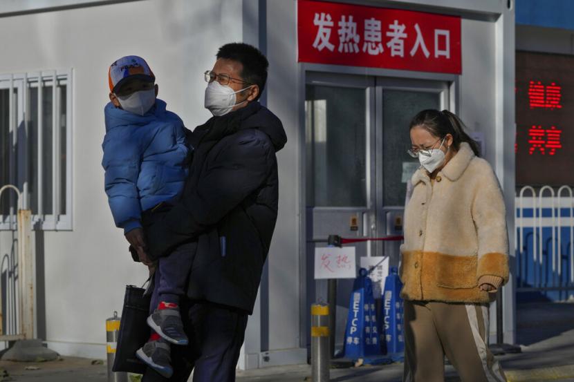 Warga berjalan di dekat klinik demam tertutup di sebuah rumah sakit di Beijing.