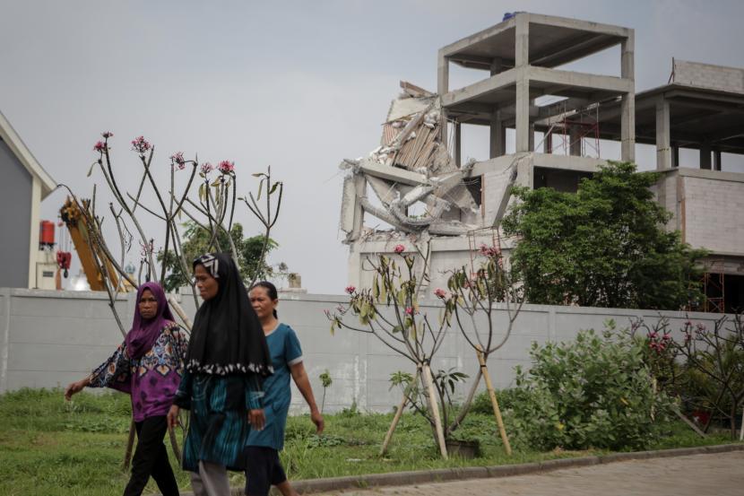 Warga berjalan di dekat lokasi bangunan SMAN 96 Cengkareng, Jakarta Barat, yang roboh saat sedang direnovasi pada Rabu (18/11/2021)