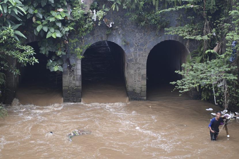 Warga berjalan di depan bangunan Jembatan Terowongan Tiga di kawasan Matraman, Jakarta Timur, Ahad (12/6/2022). Jembatan Terowongan Tiga yang ditetapkan sebagai bangunan cagar budaya oleh Pemprov DKI Jakarta tersebut kondisinya terbengkalai dan kumuh. 