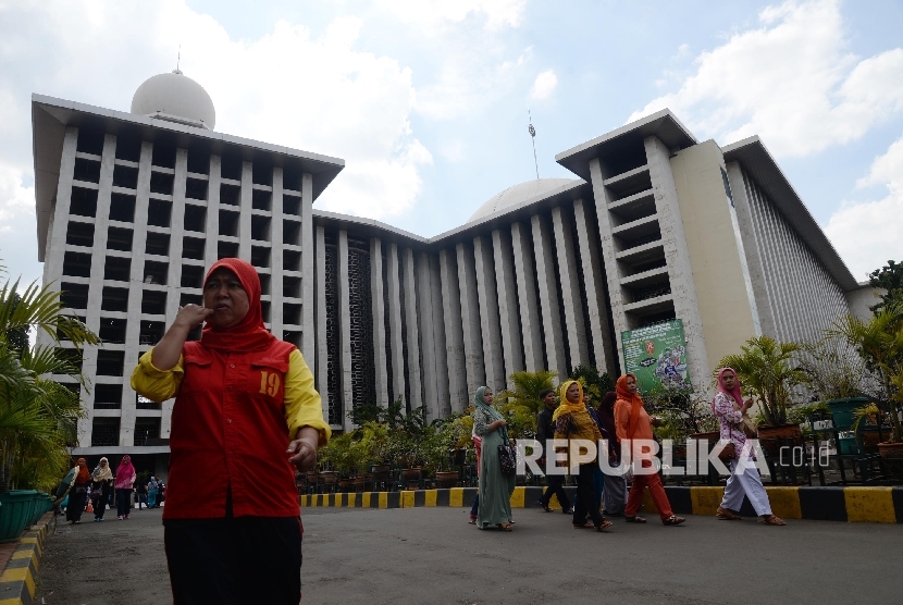  Warga berjalan di depan Masjid Istiqlal, Jakarta, Senin (2/1).