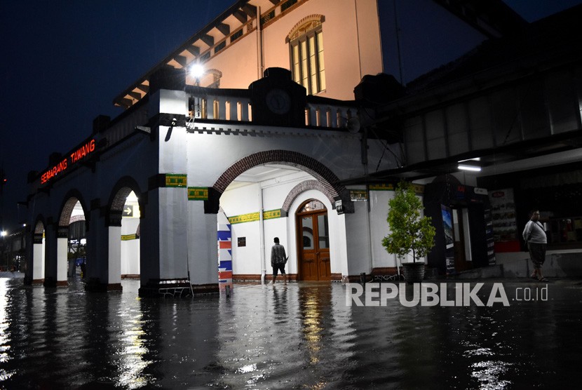 Warga berjalan di genangan air yang membanjiri ruang tunggu keberangkatan Stasiun Besar Kereta Api (KA) Tawang di Semarang, Jawa Tengah, Senin (3/12/2018) malam. 