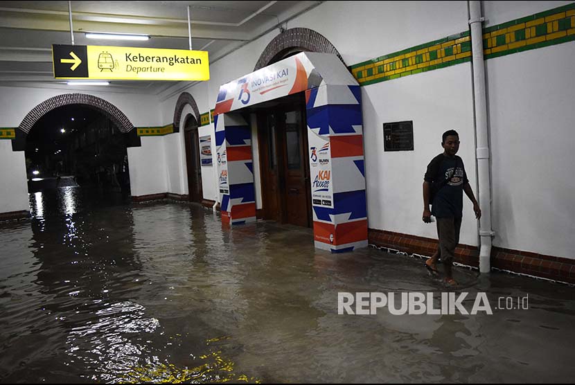 Warga berjalan di genangan air yang membanjiri ruang tunggu keberangkatan Stasiun Besar Kereta Api (KA) Tawang di Semarang, Jawa Tengah, Senin (3/12)
