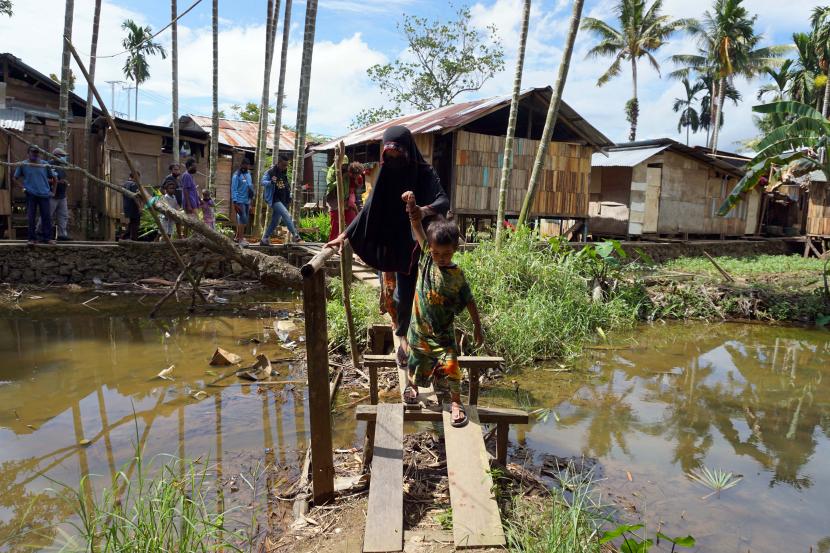 Warga berjalan di jembatan kayu di Kelurahan Remu Selatan, Kota Sorong, Papua Barat, Sabtu (20/2). Wakil Menteri Keuangan (Wamenkeu) menyebutkan realisasi anggaran untuk menekan kemiskinan di wilayah Papua mencapai Rp 225,05 miliar hingga akhir triwulan III 2021, atau 33,52 persen dari alokasi yang dianggarkan pada 2021 yaitu Rp 671,25 miliar