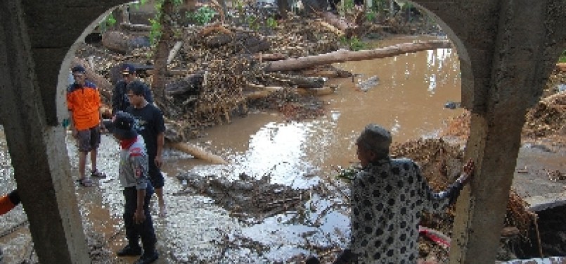 Warga berjalan di kawasan yang terkena banjir bandang, di Jorong Sawah Laweh, Nagari Simpang, Kecamatan Simpati, Kabupaten Pasaman, Sumbar, Kamis (23/2).