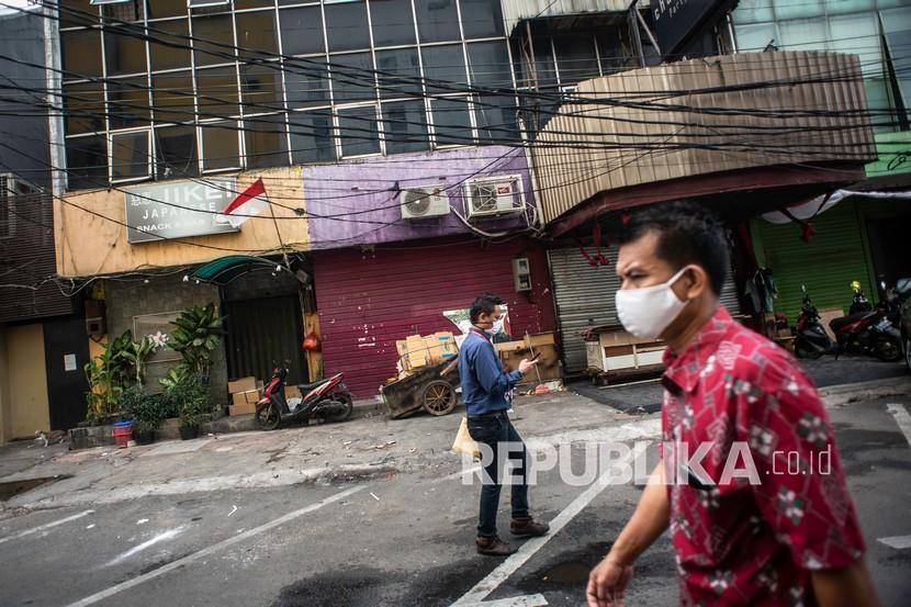 Warga berjalan di kompleks pertokoan yang tutup dan tidak beroperasi sejak penerapan PSBB COVID-19 di kawasan Blok M, Jakarta, Senin (14/9). Ekonom UGM Rimawan Pradiptyo berpendapat, pemberlakuan PSBB kali ini tidak akan sampai menghentikan roda perekonomian di Indonesia.