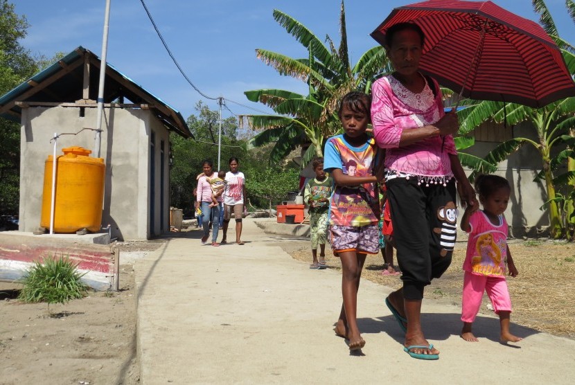 Warga berjalan di lingkungan pemukiman yang telah dialiri listrik di Desa Ustutun, Kecamatan Wetar Barat, Kabupaten Maluku Barat Daya, Provinsi Maluku, Kamis (21/9).