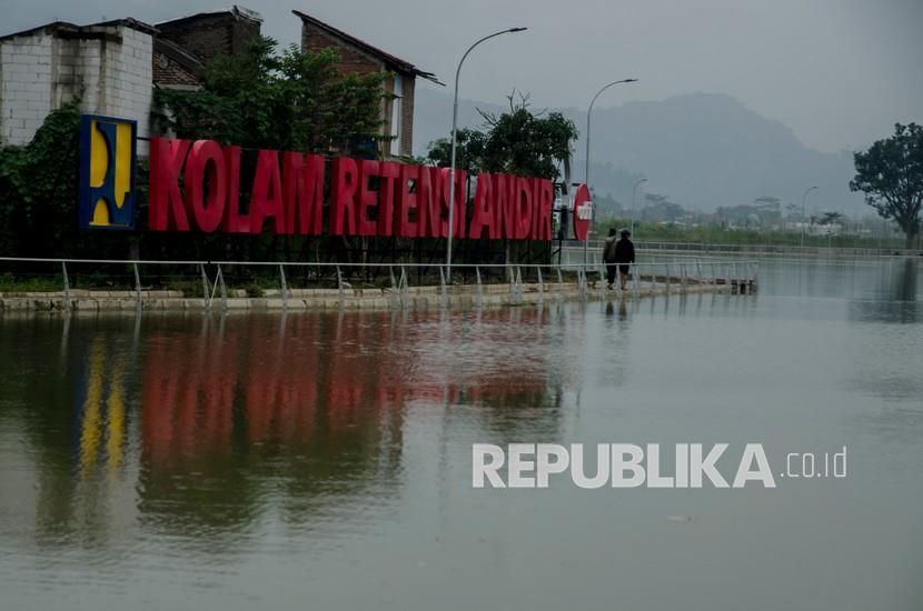 Warga berjalan di pedestrian bantaran Kolam Retensi Andir, Baleendah, Kabupaten Bandung, Jawa Barat. Pemkab Bandung mengupayakan sejumlah kolam retensi menjadi sumber air bersih.