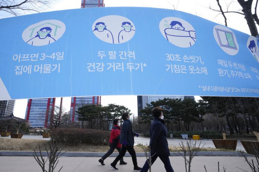Warga berjalan di sebuah taman di Seoul, Korea Selatan, Senin (24/1/2022).