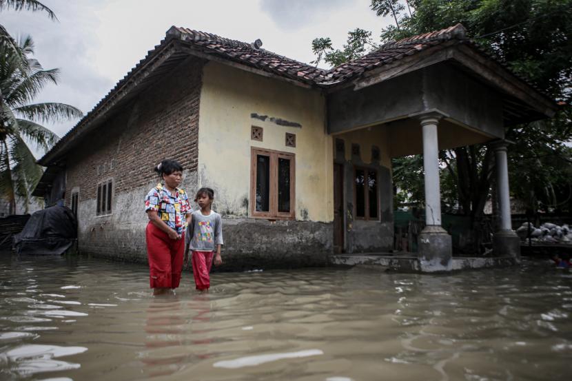 Warga berjalan di tengah banjir di Pakuhaji, Kabupaten Tangerang, Banten. Banjir masih menggenangi wilayah Pakuhaji Kabupayen Tangerang dengan ketinggian 50 cm.