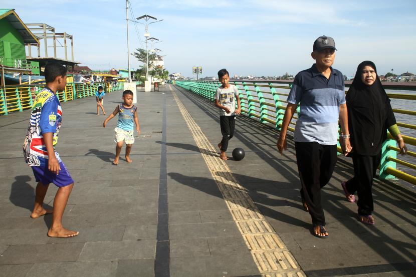 Warga berjalan-jalan di Waterfront City di Pontianak, Kalimantan Barat, Sabtu (1/1/2022). Waterfront City yang dibangun di tepian Sungai Kapuas tersebut menjadi sarana rekreasi bagi masyarakat setempat yang ingin bersantai ataupun berolahraga. 