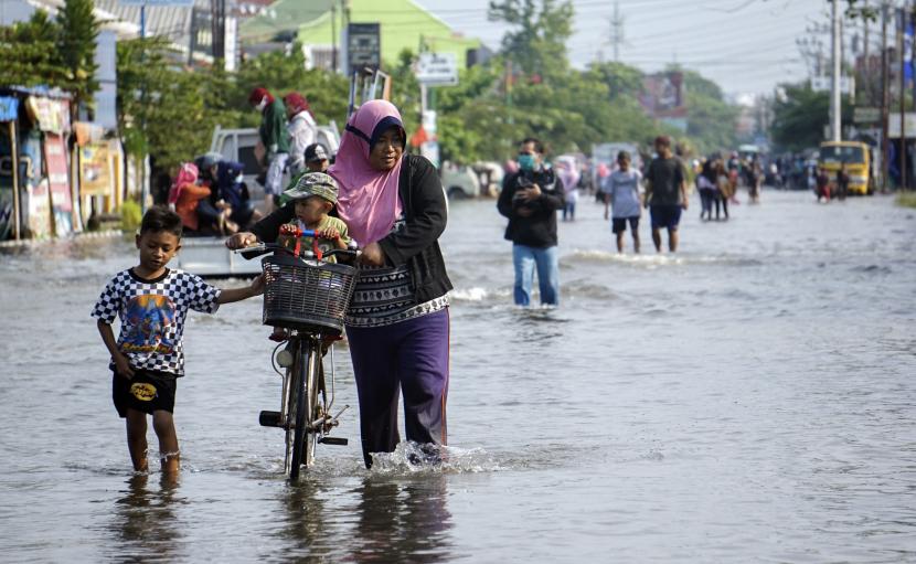 Warga berjalan melewati banjir rob di Pekalongan, Jawa Tengah, Kamis (4/6/2020). Berdasarkan data pemerintah setempat, sebanyak sekitar 7.700 Kepala Keluarga (KK) di Pekalongan Utara terdampak banjir rob, dengan kondisi rob setinggi sekitar 10-80 centimeter. 