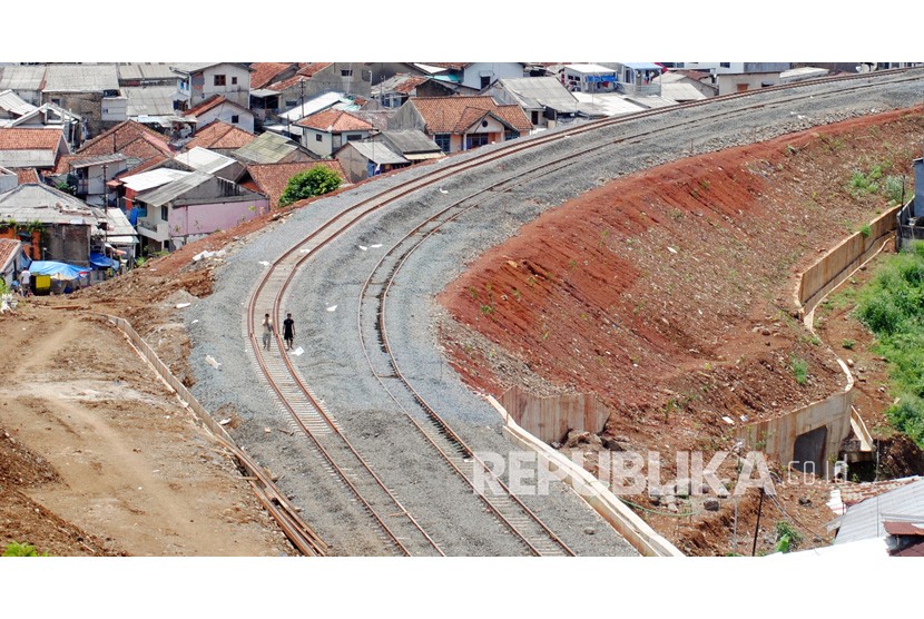 Warga berjalan melewati pembangunan jalur ganda Kereta Api (KA) Bogor-Sukabumi di Kelurahan Empang, Kota Bogor, Jawa Barat, Ahad (21/11/2021). Kementerian Perhubungan menargetkan pembangunan jalur ganda KA Bogor-Sukabumi tahap 1 yang melintasi Bogor-Cigombong selesai pada Maret 2022. 