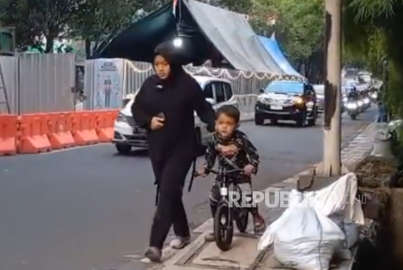 Warga berjalan melintasi trotoar di Jalan Simatupang, Jakarta Selatan, Ahad (24/8/2025).