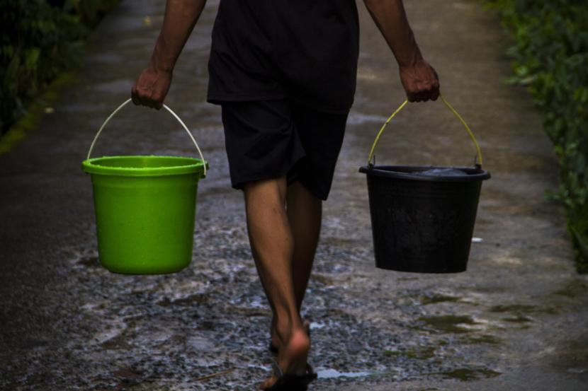 Warga berjalan membawa air bersih. Pemerintah Kota Makassar meminta Perusahaan Umum Daerah Air Minum (PDAM) untuk memperluas cakupan pelayanan air bersih hingga 85 persen. Layanan air bersih saat ini baru mencapai 68 persen.