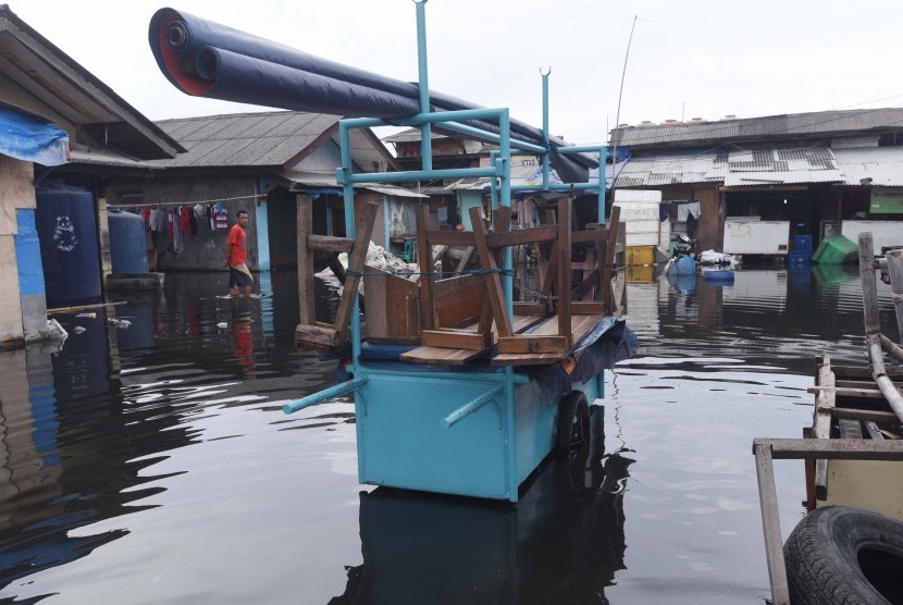 Warga berjalan menembus banjir di Kawasan Muara Angke, Jakarta, Selasa (10/1).