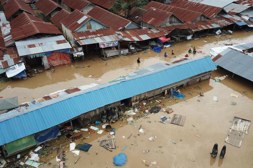 Warga berjalan menembus banjir di Pasar Youtefa Abepura, Jayapura, Papua, Jumat (7/1/2022). Badan Nasional Penanggulangan Bencana (BNPB) melaporkan telah terjadi 68 kejadian bencana alam pada pekan pertama awal 2022 atau dalam periode 1 hingga 8 Januari. 