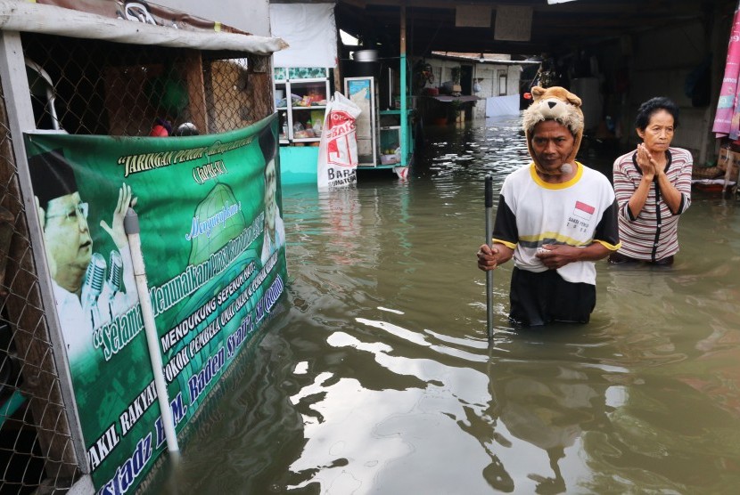 Warga berjalan menembus banjir di Sumatra Utara (ilustrasi). BMKG mengingatkan masyarakat agar waspada potensi terjadinya banjir di Sumatra Utara.