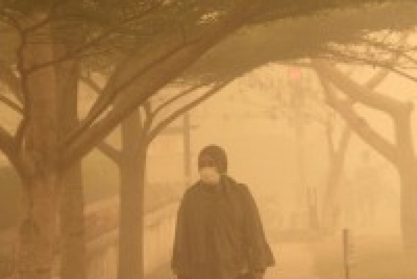 Warga berjalan menembus kabut asap di kawasan Tugu Soekarno, Kota Palangkaraya, Kalimantan Tengah, Selasa (20/10).