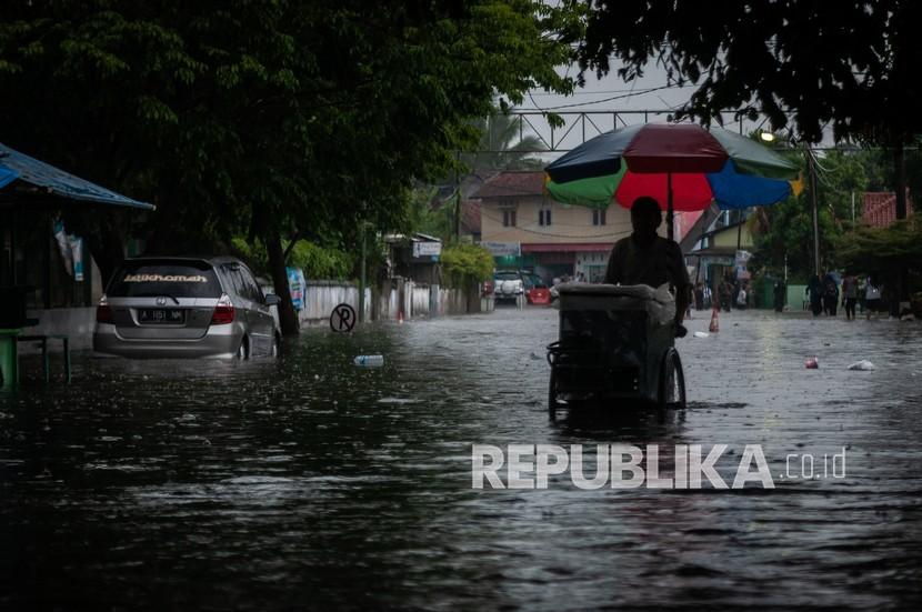 Warga berjalan menerobos banjir di Rangkasbitung, Kabupaten Lebak, Provinsi Banten, Rabu (12/1/2022). 