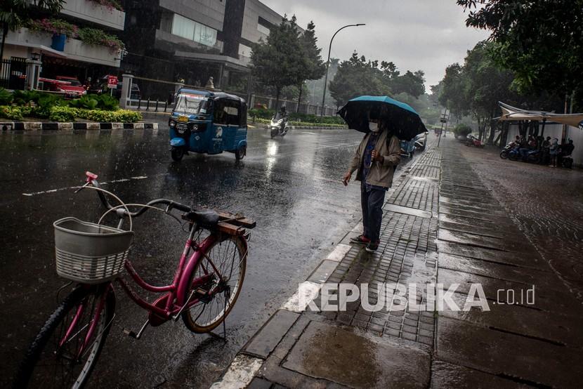 Warga berjalan menggunakan payung saat hujan di kawasan Kelurahan Gambir, Jakarta, Kamis (16/12/2021). Badan Meteorologi, Klimatologi, dan Geofisika (BMKG) memprediksi hujan dengan intensitas sedang berpotensi turun di Jakarta Selatan dan Jakarta Timur pada siang hari dan hujan ringan berpeluang turun di Jakarta Barat pada siang dan malam hari serta di Jakarta Pusat