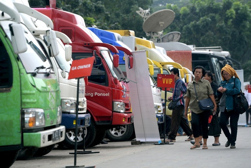 Warga berjalan menuju mobil kas keliling penukaran uang pecahan di Lapangan IRTI, Monas, Jakarta, Senin (5/6).