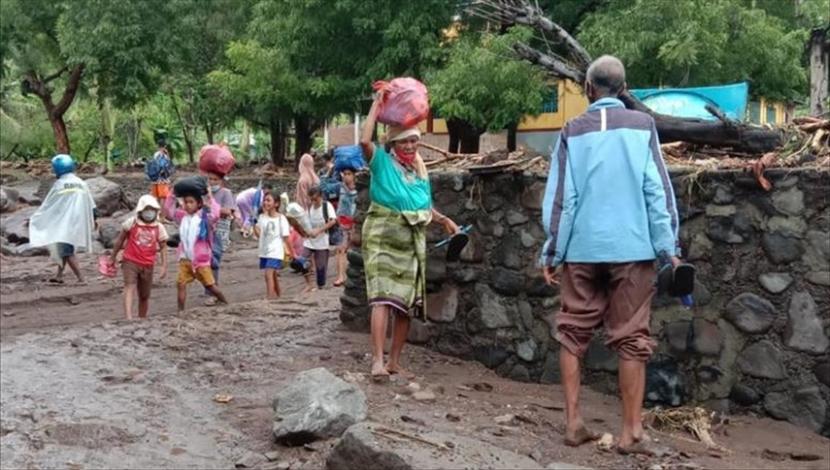 Warga berjalan menuju tempat pengungsian akibat banjir bandang di Kabupaten Lembata, Provinsi Nusa Tenggara Timur pada 5 April 2021. 