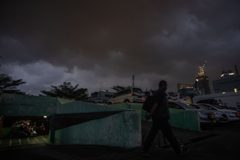 Warga berjalan saat awan mendung di kawasan Menteng, Jakarta, Rabu (28/8/2019). (Antara/Aprillio Akbar)