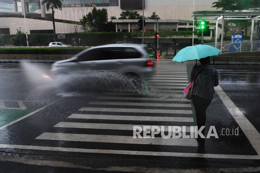 Warga berjalan sambil membawa payung saat hujan deras (ilustrasi). Warga Kota Depok, Jawa Barat, diimbau waspada akan cuaca ekstrem.
