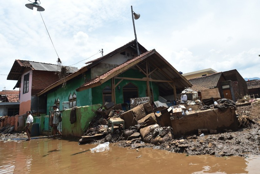 Warga berjalan seusai melaksanakan Salat Jumat di Masjid Al Mukmin yang berada di lokasi bencana banjir bandang aliran Sungai Cimanuk, Kampung Cimacan, Tarogong, Kabupaten Garut, Jawa Barat, Jumat (23/9). 