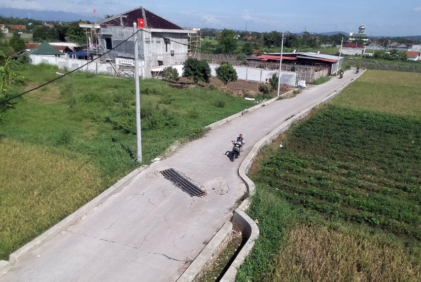 Warga berkendara di jalan yang dibangun mengunakan dana desa 2018, di Desa Laladon, Bogor, Jawa Barat, Jumat (28/12/2018). 