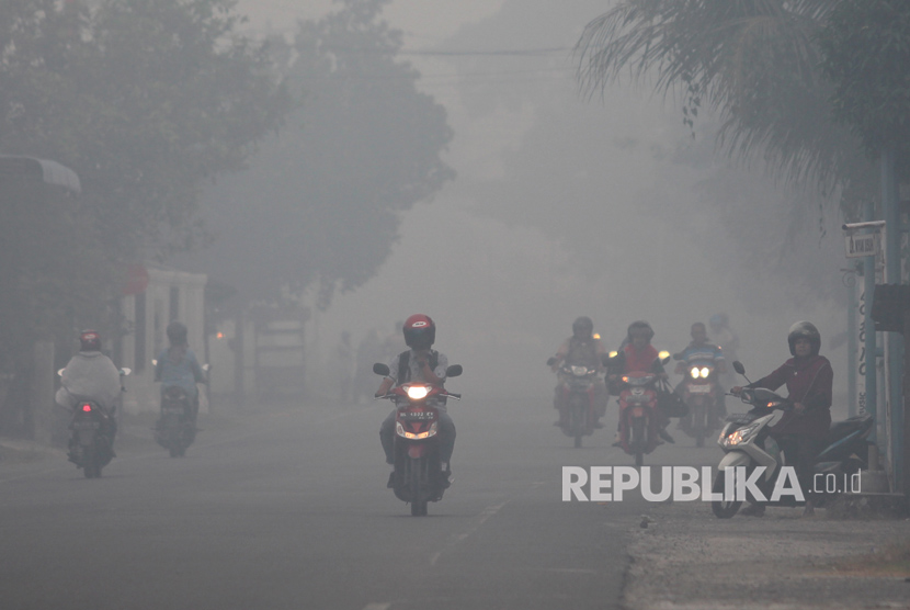 Warga berkendara menembus kabut asap di Jalan Nasional Banda Ace Tapak Tuan, Desa Suak Raya, Johan Pahlawan, Aceh Barat, Aceh, Kamis (27/7).